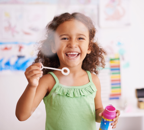 little girl blowing bubbles at spring break camp